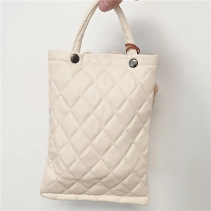 Detail view of cream quilted leather tissue holder with small bear pattern and rivet buttons