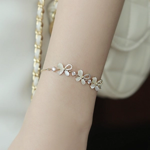 Elegant gold bracelet with opal-like stones and crystals on a female wrist