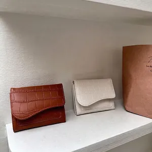 Portafoglio corto da donna con texture coccodrillo e patta curva dal design elegante