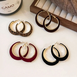 Flat lay of vintage C-shaped flocked earrings in leopard, burgundy, brown, and black