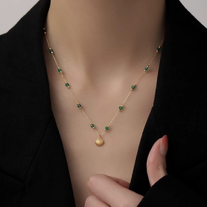 Elegant gold necklace with emerald green beads and a delicate shell pendant for women