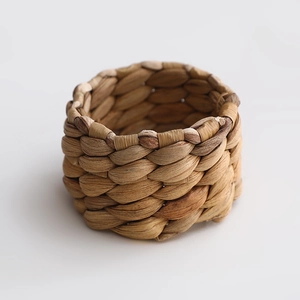 Handcrafted round napkin ring made of natural woven straw on a clean white background