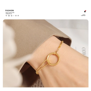 Detail of 18K gold plated layered bead and box chain bracelet on female wrist