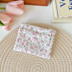 Porte-cartes en toile florale avec bouton coeur sur tapis tressé et tulipes