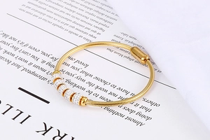 Détail du bracelet chaîne serpent doré avec cinq perles diamantées et fermoir magnétique