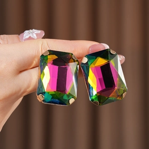 Detailed view of vintage rectangular earrings with colorful crystals in gold settings