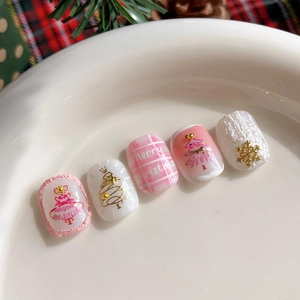 Golden Christmas tree nail stickers with snowflake patterns on pink and white press-on nails