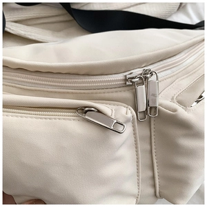 Close-up of white nylon crossbody bag with durable silver metal zippers and multi-layers
