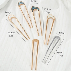 Detailed view of U-shaped metal hair pins with shell inlay and precise dimensions