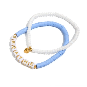 Détail de l'ensemble de bracelets en perles bleues et blanches avec charms dorés