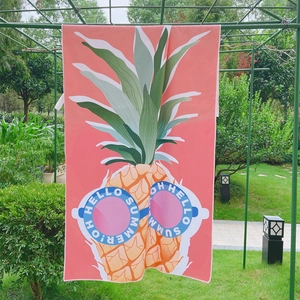 Detail of pink double-sided velvet beach towel featuring a summer pineapple print design