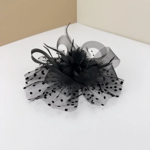 Detailed view of black retro fascinator featuring polka dot mesh and delicate feathers