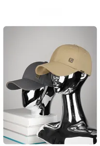 Detail von Khaki und Anthrazit Baseball Caps mit Metall-Logo und seitlichem Etikett
