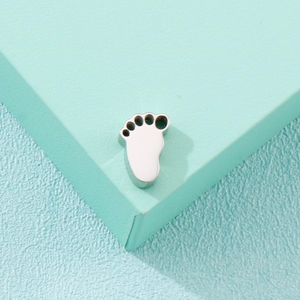 Polished stainless steel footprint pendant on light blue textured background for necklace