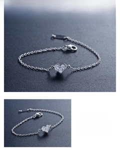 Detail view of S925 sterling silver heart bracelet with sparkling stones on dark surface