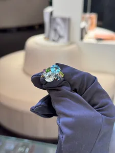 Detail of 18K gold ring featuring a cluster of colorful zircon stones in various shapes