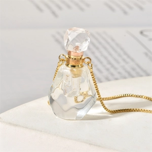 Detailed macro view of faceted crystal perfume bottle pendant with golden box chain