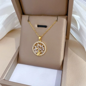 Elegant gold Tree of Life necklace with white crystals on a premium jewelry box