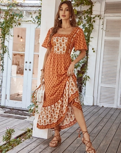 Detail view of orange floral print midi dress featuring bohemian patterns and ruffled hem