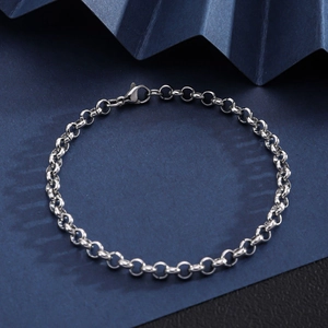 Detail view of silver stainless steel curb chain bracelet with lobster clasp on blue background