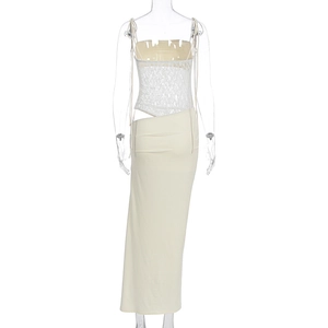 Detail of white lace camisole top and cream maxi skirt with waist cutout design