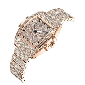Détail de la montre tonneau en or rose avec pavage de diamants et cadran floral