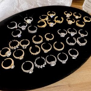 Flat lay of heart and geometric zircon rings in gold and silver on a black velvet tray