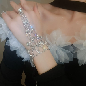 Close-up of sparkling rhinestone hand harness ring bracelet with mesh design in silver