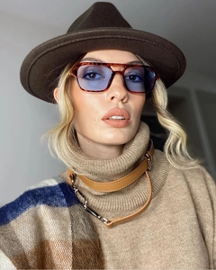 Detail of tortoise frame sunglasses with blue lenses styled with autumn winter fashion wear