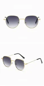 Close-up of retro gold metal frame sunglasses with gradient gray lenses and black tips