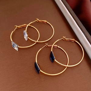 Detail of 24k gold plated hoop earrings with white and dark blue diamond cut crystals