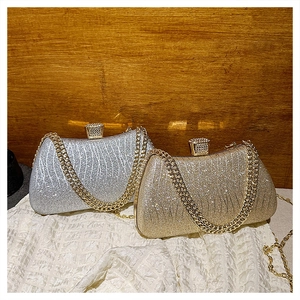 Close-up of gold and silver chain evening bags with textured wavy pattern and diamond buckle