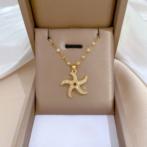 Detail of a rotating starfish necklace with red center gem and diamonds in a gift box