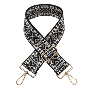 Ethnic style wide bag strap with black, white, and brown geometric patterns and gold clips