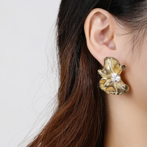 Elegant 18K gold-plated irregular flower earrings worn by a model with shimmering crystals