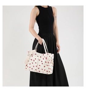 Detail of strawberry print corduroy tote bag showing front pockets and shoulder straps