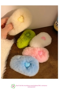 Close-up of heart-shaped plush hair clips in cream, green, white, pink and blue colors