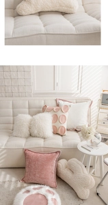 Detail of pink velvet and white faux fur throw pillows in a cozy modern Nordic living room