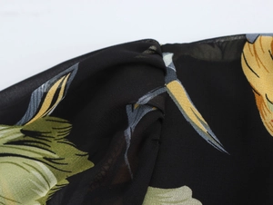 Dettaglio del tessuto in chiffon floreale con trama e volant sulla superficie dell'abito