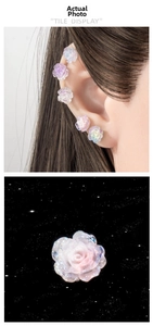 Macro detail of resin camellia ear studs with blue gradient and iridescent glitter