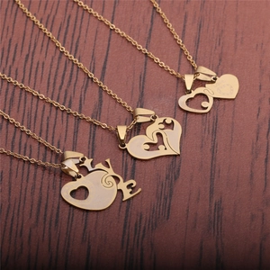 Colliers en acier titane avec pendentifs en forme de cœur LOVE sur fond de bois