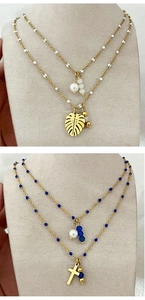 Detail of layered 18k gold plated necklaces with natural stones and pearl pendants
