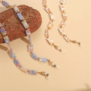 Close-up of resin eyewear chains with marble textures and gold lobster clasps