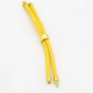 Macro view of adjustable bright yellow braided cord with gold metal slide buckle for DIY