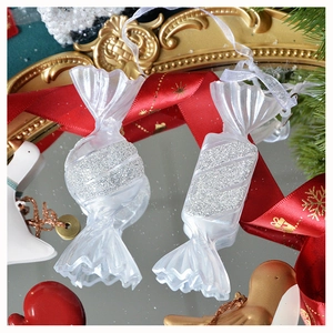 Dettaglio macro di decorazione natalizia trasparente a forma di caramella con glitter argento