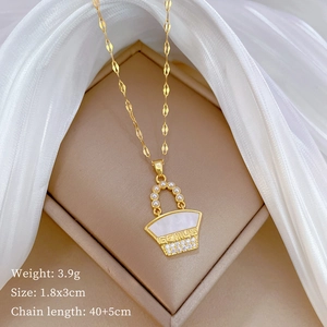 Close-up of gold titanium necklace with pearl and zircon bag pendant featuring GENIUS engraving