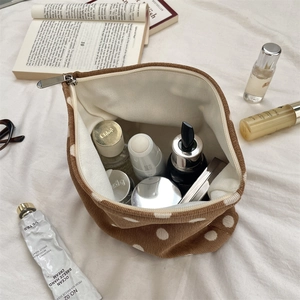 Detailed interior view of brown polka dot corduroy cosmetic bag with diverse skincare items