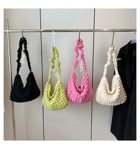 Popcorn texture shoulder bags in black, lime green, pink, and off-white colors