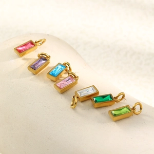 Macro detail of 18K gold plated stainless steel pendants with colorful rectangle birthstones