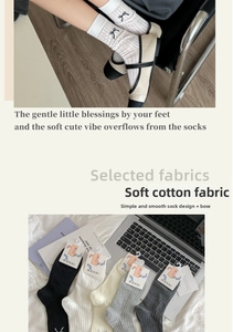 Detailed close-up of ribbed cotton knee-high socks with delicate black bow accents
